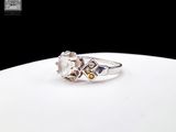 a picture of a ring with a white diamond and a yellow sapphire