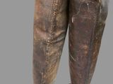 pair of leather boots with holes in them on a gray background