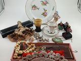 a table with a plate, a tray with beads, a tray with beads, and a plate with a cup and saucer on it