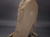 a military uniform on a mannequin stand against a gray background