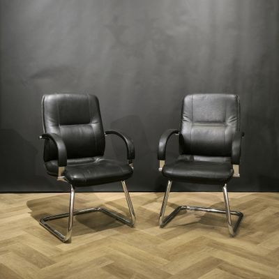Paire de fauteuils de bureau en skaï noir et métal.