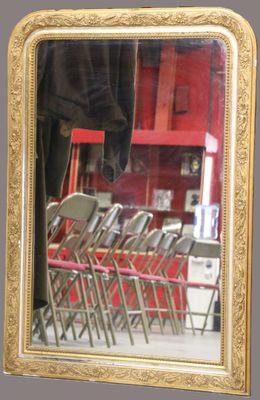 un miroir à cadre doré accroché au mur d'un restaurant