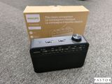 une radio noire posée par terre à côté d'une boîte