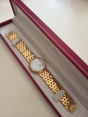 deux montres dans un coffret posé sur une table, sur fond blanc