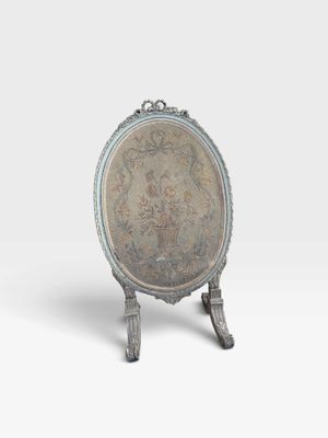 un plateau en argent orné d'un motif floral, posé sur un socle