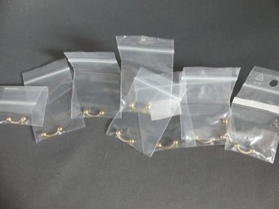 five bags with gold rings on them sitting on a table
