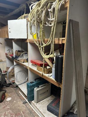 a room with a lot of clutter and tools on the shelves