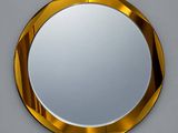 un miroir rond avec un cadre doré accroché au mur