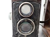 a brown and black camera sitting on a white surface