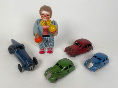 cinq petites voitures et une figurine de clown posées sur une surface blanche