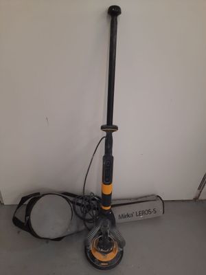 an orange and black scooter sitting on top of a floor next to a white wall