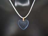 a close up of a necklace with a blue heart on it