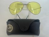Lunettes de soleil Ray-Ban à verres jaunes, présentées dans un étui sur un fond blanc