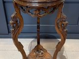 une vieille table en bois avec un plateau en marbre, posée sur un sol carrelé