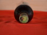 a bottle of wine sitting on a red cloth