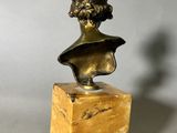 a bronze bust of a woman on a marble base