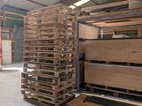 many pallets of wood stacked up in a warehouse