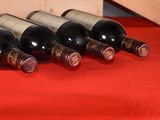 several bottles of wine are lined up on a red table cloth