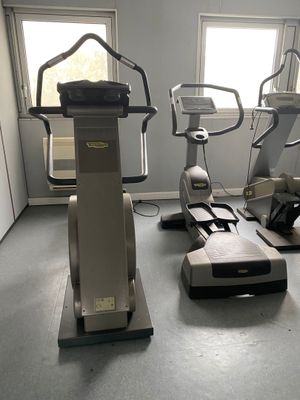 une salle de sport équipée d'une rangée d'appareils de musculation fixes
