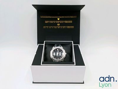 l'image d'une montre dans une boîte sur une surface blanche