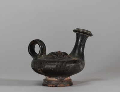 Guttus en terre cuite à vernis noir, panse annulaire côtelée… - Photo 1