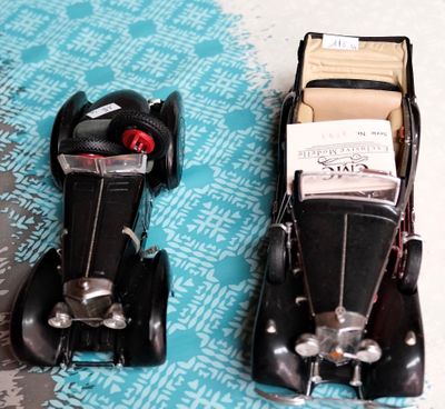 deux voitures jouets assises l'une à côté de l'autre sur une table