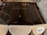 a glass vase with a label on it sitting on a table