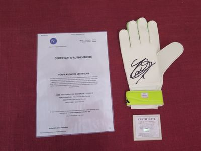 the signed glove is next to a certificate on a red cloth