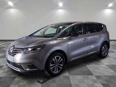 une camionnette argentée garée dans une pièce au sol en damier