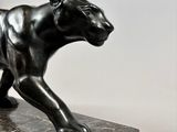 a statue of a black panther on a marble base