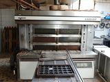 a kitchen with a stove, oven, sink, and cabinets