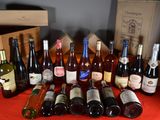 many bottles of wine sitting on a table with a red table cloth
