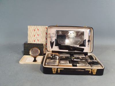 une valise ouverte posée sur une table, contenant des objets en argent