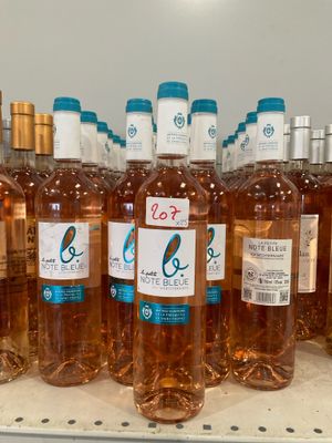 Des bouteilles de vin rosé sont alignées sur une étagère dans un magasin