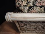 a white chair with a floral upholstered back