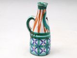 a blue and orange vase with a handle on a white surface