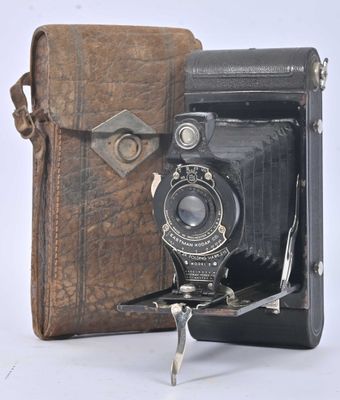 an old photo of an old camera with a leather case