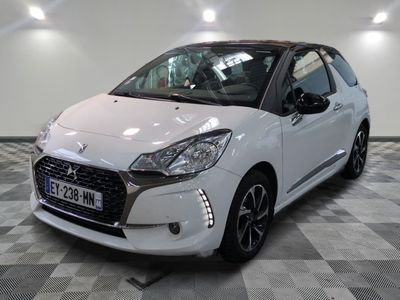 la petite voiture blanche est garée sur un sol en damier