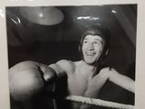 photographie en noir et blanc d'un homme dans un ring de boxe tenant un gant de boxe