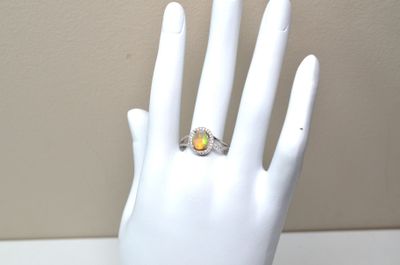 une main de mannequin blanche ornée d'une bague jaune