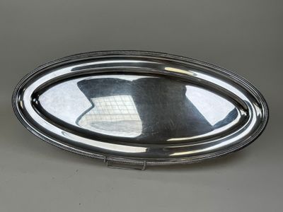 un plateau ovale en argent surmonté d'un miroir