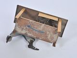 a small metal box with a pair of black shoes on it