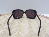 black sunglasses on a woven basket on a white surface