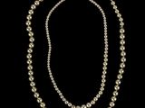 un ensemble composé d'un collier et d'un bracelet en perles blanches sur fond noir