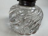 a clear glass bottle with a black lid on a table