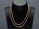 un collier à chaîne en or sur un mannequin, sur fond noir