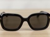a pair of black sunglasses sitting on top of a wooden table
