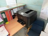 a printer that is sitting on a desk next to a chair