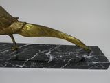 statue of a golden bird on a marble base on a white background