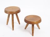 two small wooden stools sitting next to each other on a white surface